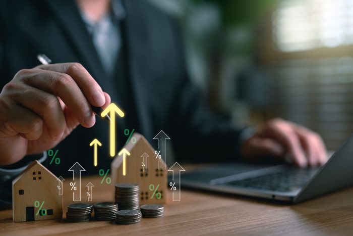 Real,Estate,Investor,Analyzing,Property,Value,Growth,With,Stacked,Coins,