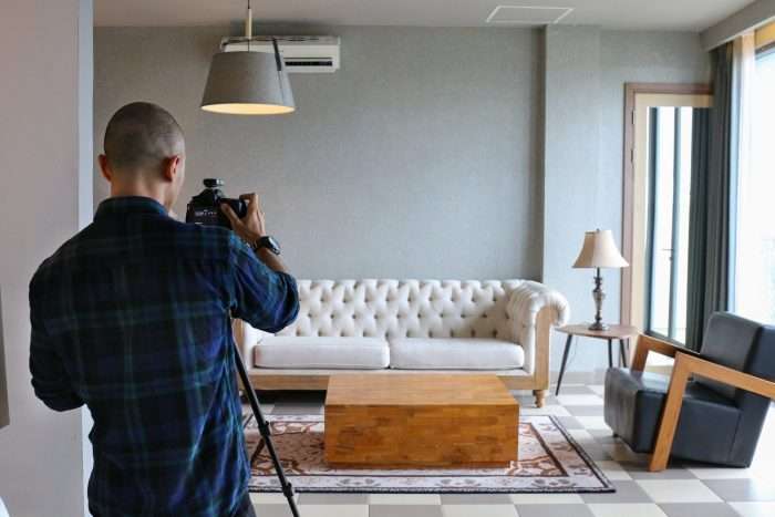 Male,Professional,Photographer,Shooting,Indoors,In,The,Living,Room,,Home