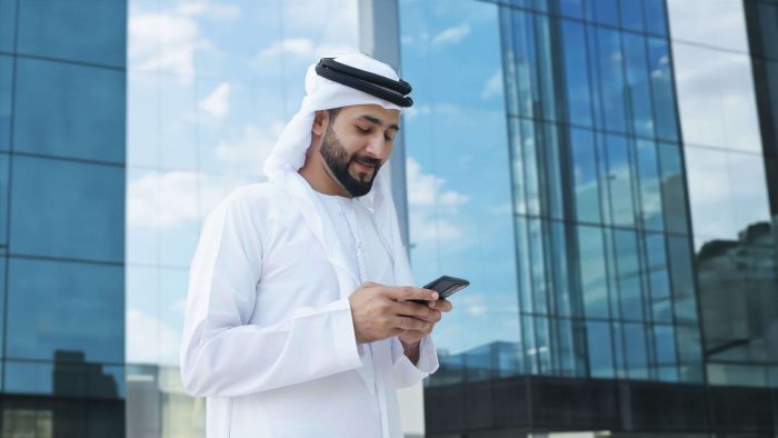 Arab,Businessman,With,High-rise,Buildings,With,Glass,Windows,As,Background.