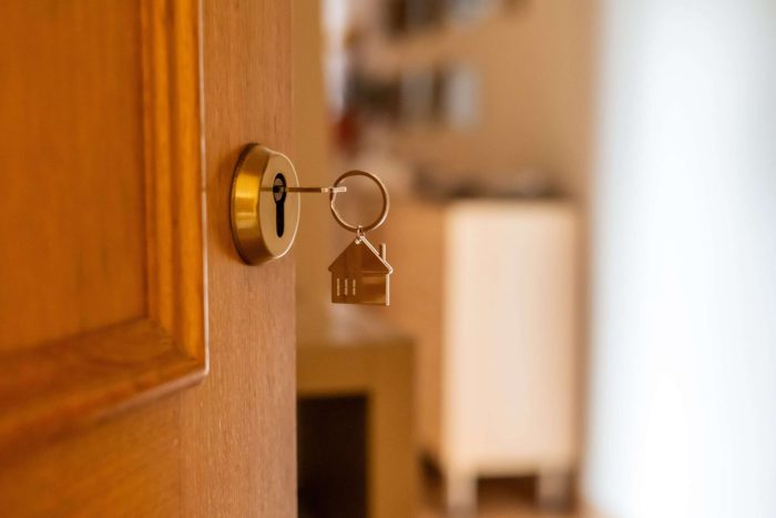 Golden,Key,With,A,Small,House,Keychain,Opening,A,Wooden